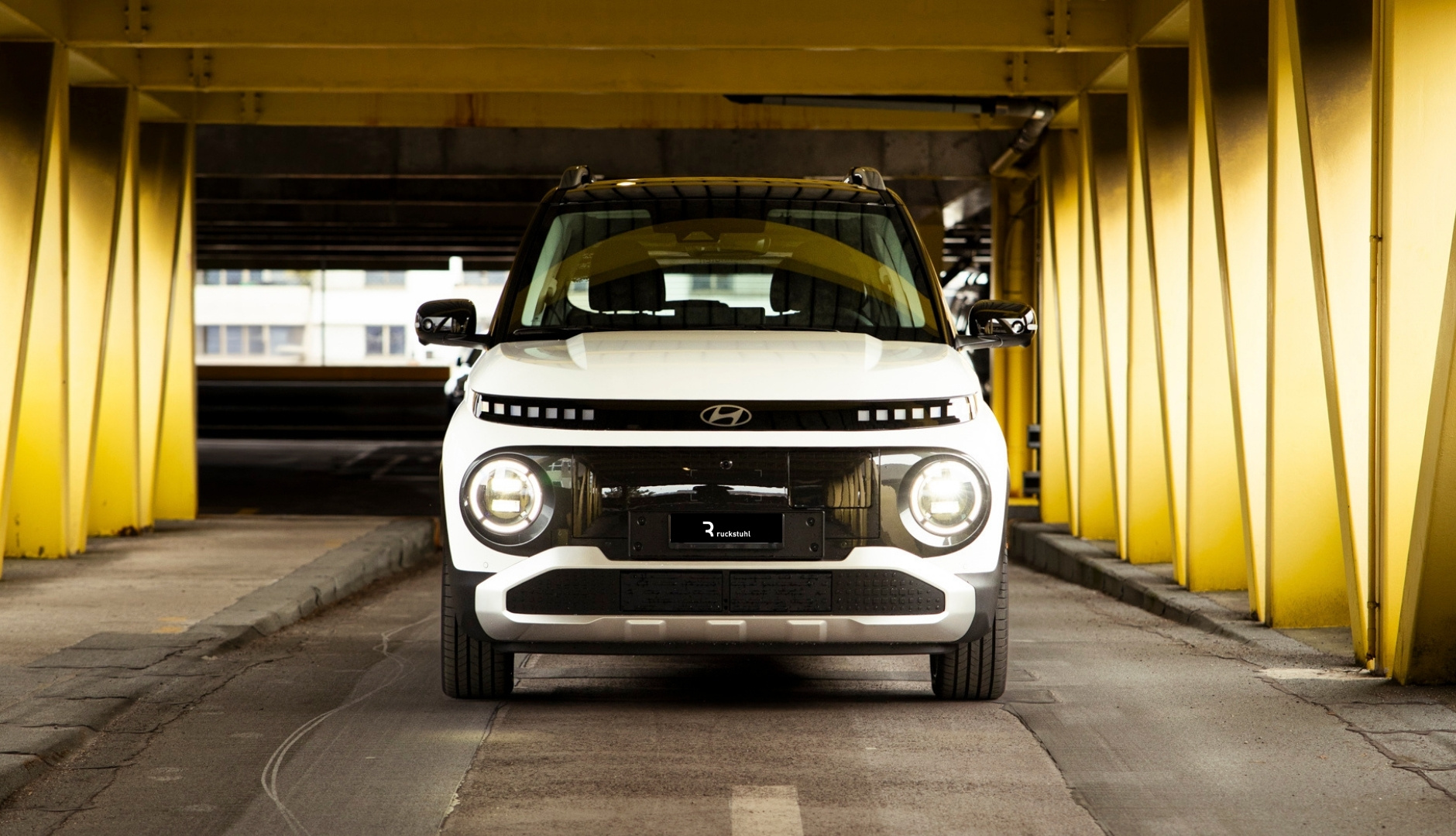 Weisser Hyundai in gelbem Parkhaus fotografiert.
